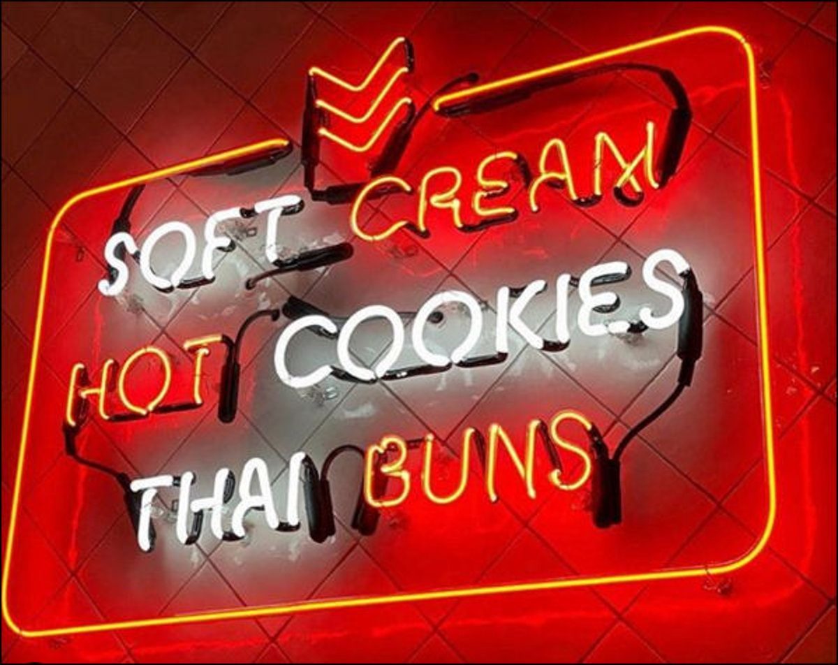 Red, white and yellow neon window sign reading Soft Cream, Hot Cookies, Thai Buns